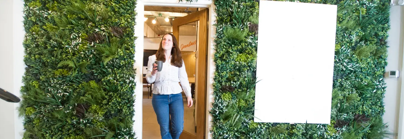 Member walking through doorway in our downstairs coworking area.